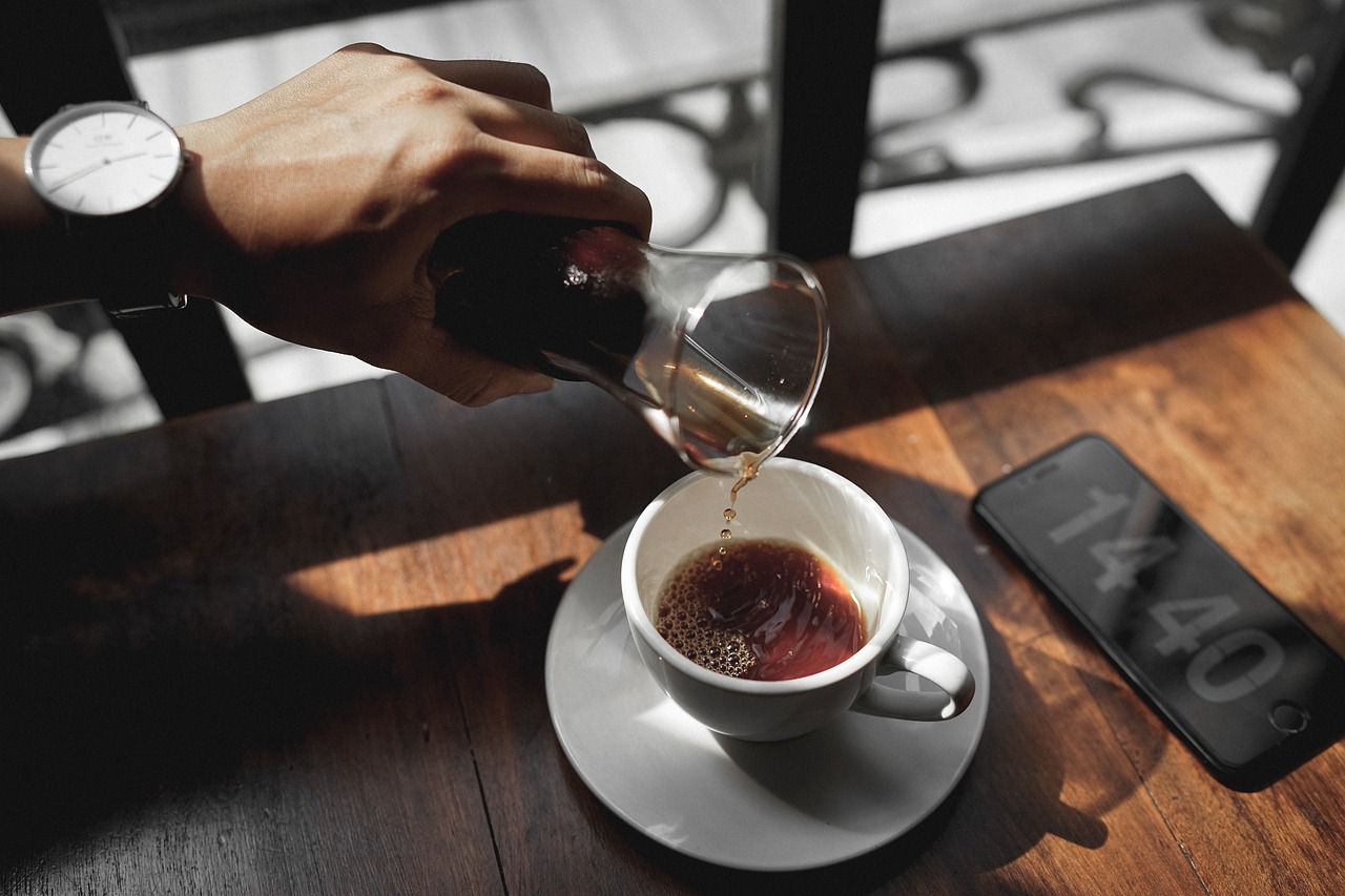 カップにコーヒーを注ぐ手